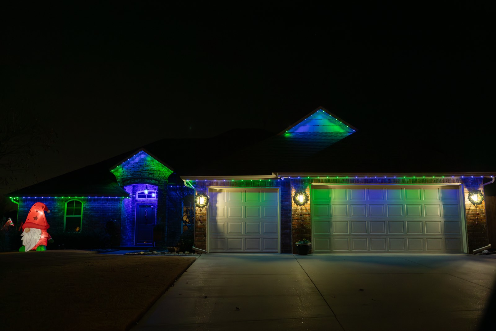 Permanent LED trim lighting glowing along a two-story roofline at night